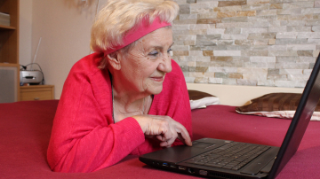 Ältere Frau in Fitnessbekleidung am PC