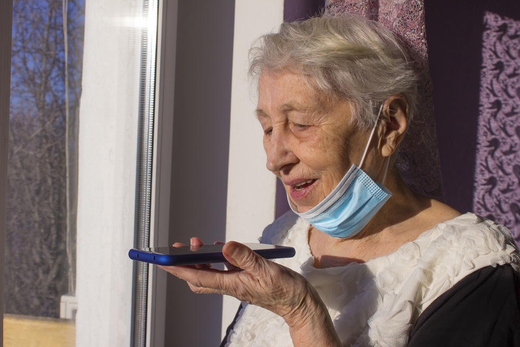 Ältere Frau spricht in ein Smartphone